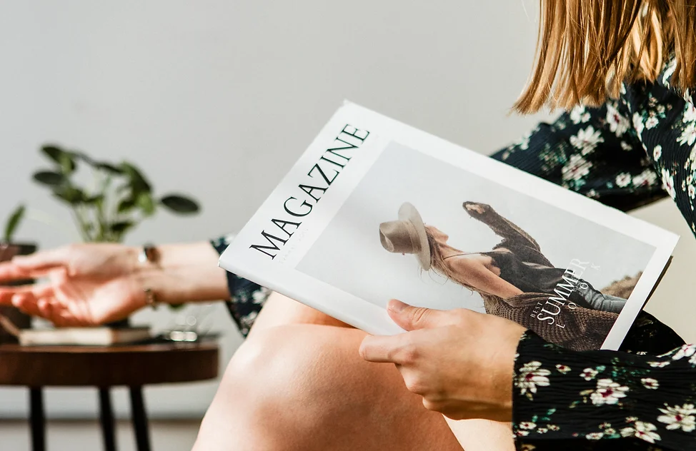 Woman with a cup of tea reading a magazine